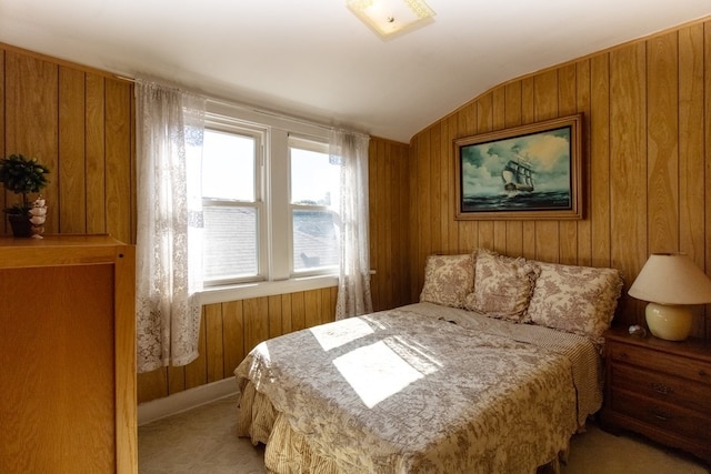 bedroom with wooden walls, lofted ceiling, and light colored carpet