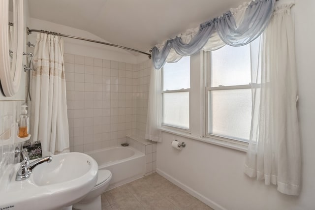 full bathroom featuring tile patterned flooring, sink, lofted ceiling, shower / bathtub combination with curtain, and toilet