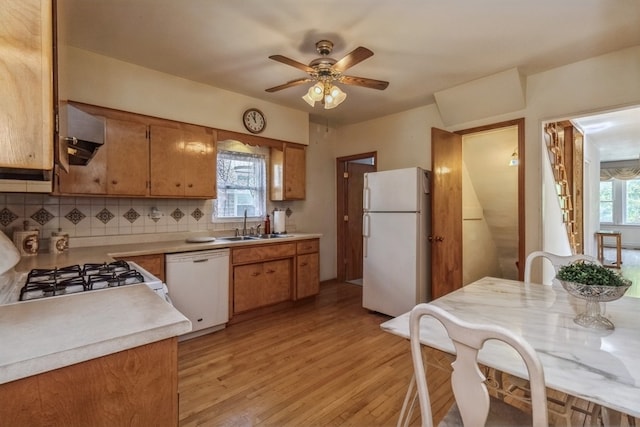 kitchen featuring decorative backsplash, a wealth of natural light, white appliances, and light hardwood / wood-style floors