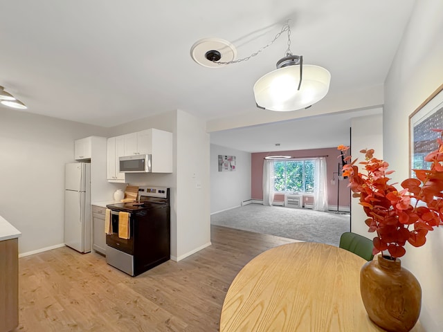 kitchen featuring appliances with stainless steel finishes, light wood-type flooring, and white cabinetry