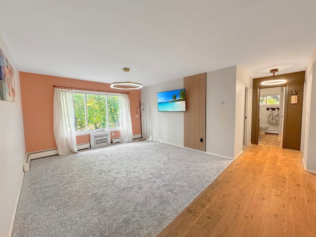 empty room with a baseboard radiator and light hardwood / wood-style flooring