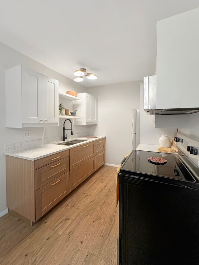 kitchen featuring sink, light hardwood / wood-style flooring, black / electric stove, white fridge, and white cabinets