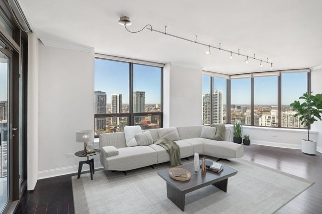 living room featuring ornamental molding, dark hardwood / wood-style flooring, and a wealth of natural light