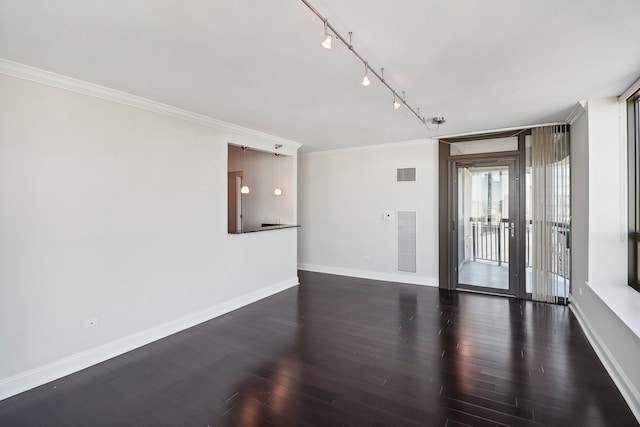 empty room with ornamental molding, dark wood-type flooring, and track lighting