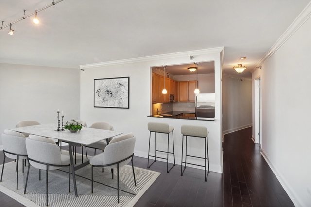 dining room with crown molding and dark wood-type flooring