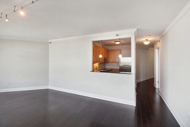 unfurnished living room with ornamental molding, sink, dark wood-type flooring, and rail lighting