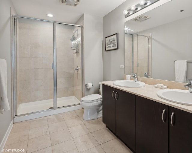 bathroom featuring vanity, a shower with shower door, and toilet