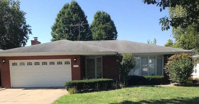 ranch-style house with a garage and a front lawn