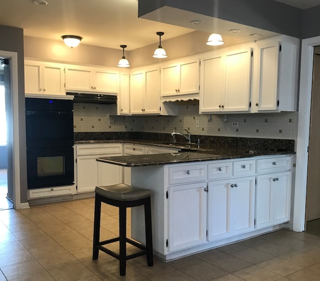 kitchen featuring decorative backsplash, dark stone countertops, white cabinetry, black appliances, and sink