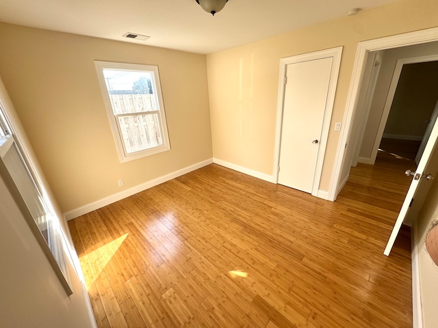 unfurnished bedroom with light wood-type flooring and a closet