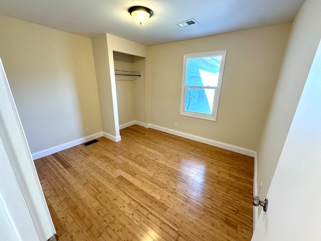 unfurnished bedroom featuring a closet and light hardwood / wood-style floors