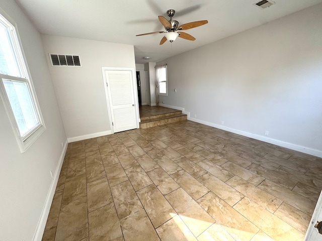 spare room featuring ceiling fan and plenty of natural light