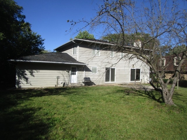 back of property featuring a yard