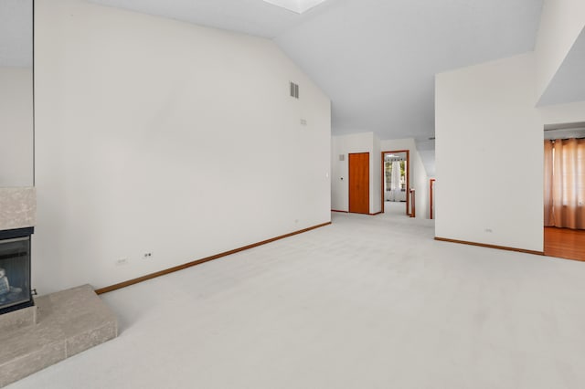 living room featuring a healthy amount of sunlight, lofted ceiling, light carpet, and a fireplace