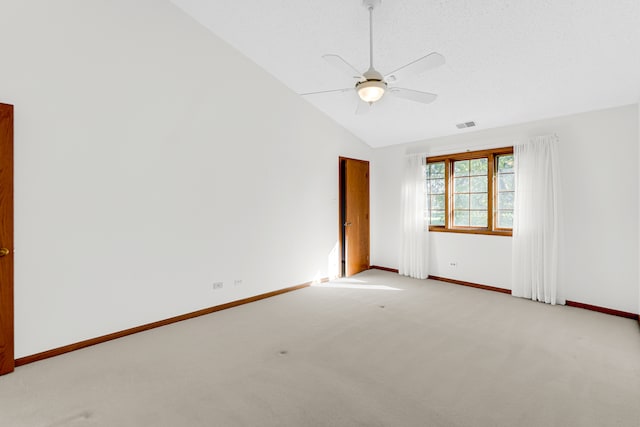 empty room with light carpet, lofted ceiling, ceiling fan, and a textured ceiling