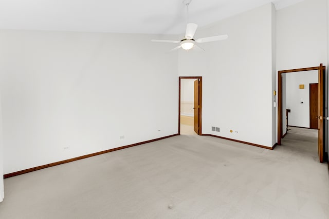 empty room with ceiling fan, light colored carpet, and high vaulted ceiling