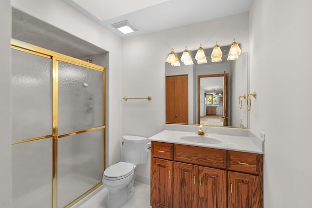 bathroom with vanity, toilet, and a shower with door