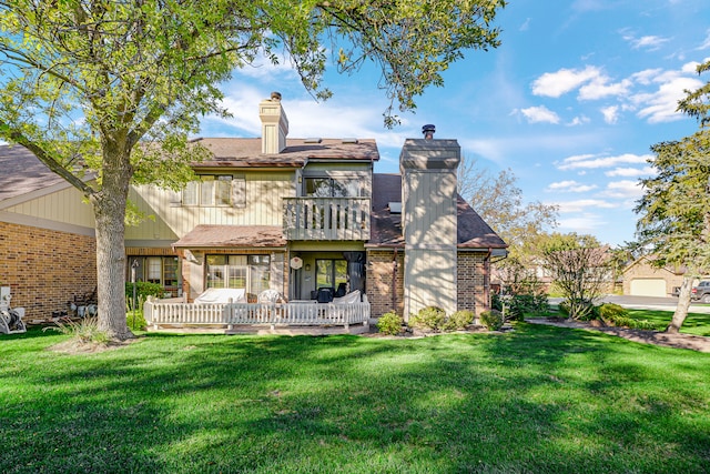 rear view of property featuring a lawn, a balcony, and a garage