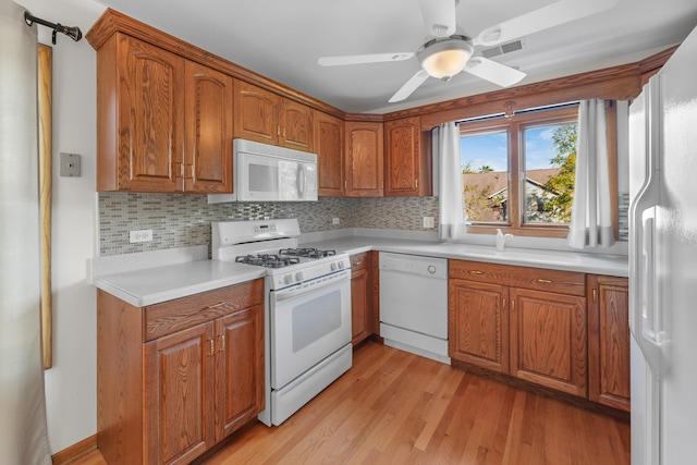 kitchen with decorative backsplash, white appliances, light hardwood / wood-style floors, and ceiling fan