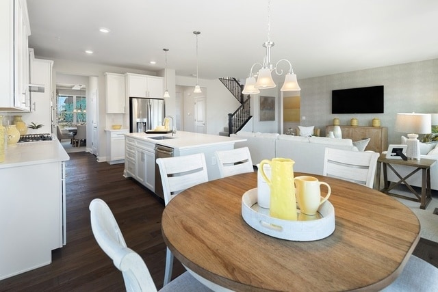 dining room with an inviting chandelier, dark wood-type flooring, and sink