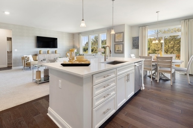 kitchen featuring hanging light fixtures, sink, plenty of natural light, and white cabinetry