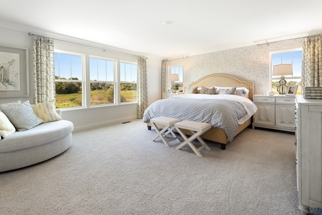 bedroom featuring multiple windows, crown molding, and light carpet