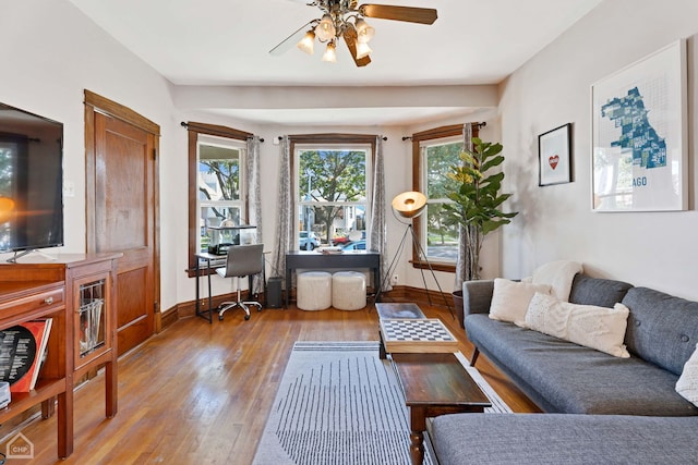 living area with wood-type flooring and ceiling fan