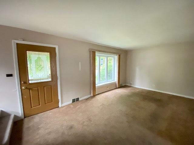 foyer entrance featuring carpet flooring