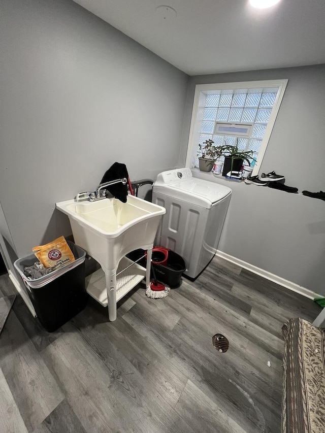 clothes washing area with dark hardwood / wood-style floors and sink