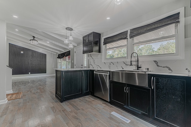 kitchen with light wood-type flooring, a healthy amount of sunlight, stainless steel dishwasher, and beam ceiling