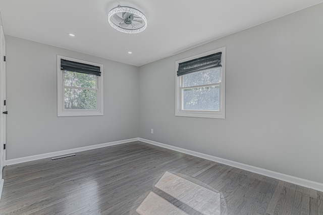 unfurnished room with ceiling fan and dark wood-type flooring