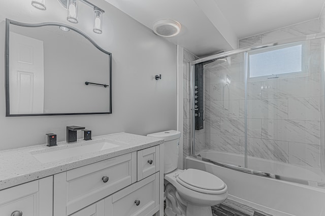 full bathroom featuring wood-type flooring, combined bath / shower with glass door, vanity, and toilet