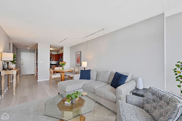 living room featuring rail lighting and light hardwood / wood-style floors