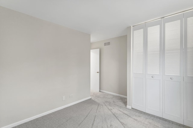 unfurnished bedroom with a closet and light carpet