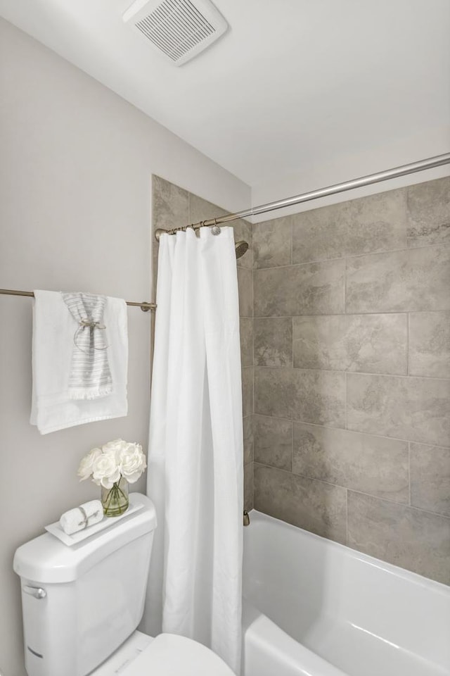 bathroom featuring toilet and shower / bath combo