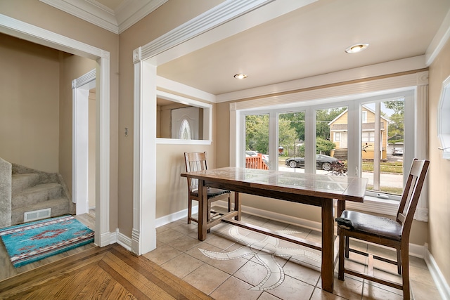 dining area with light tile patterned flooring and ornamental molding