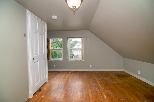 additional living space featuring hardwood / wood-style floors and vaulted ceiling