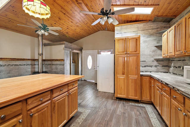 kitchen featuring ceiling fan, vaulted ceiling with skylight, wood ceiling, and dark wood-type flooring