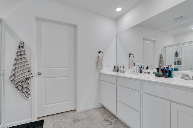 bathroom with a shower with door and vanity