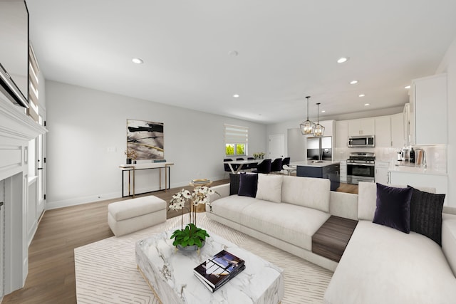 living room with an inviting chandelier and light wood-type flooring