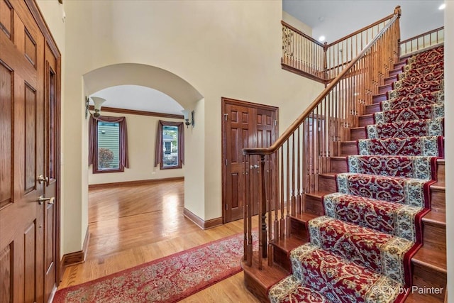 foyer featuring a high ceiling, light hardwood / wood-style floors, and crown molding