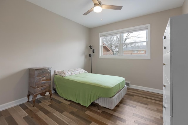 bedroom with visible vents, baseboards, and wood finished floors