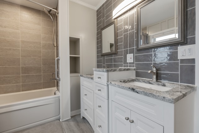 bathroom with vanity, ornamental molding, bathing tub / shower combination, hardwood / wood-style floors, and decorative backsplash