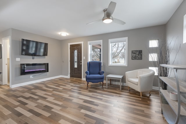 sitting room with ceiling fan and hardwood / wood-style flooring