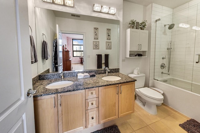 full bathroom featuring tile patterned floors, toilet, vanity, and combined bath / shower with glass door