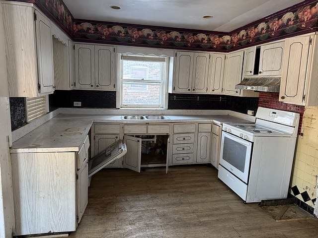 kitchen with white range, sink, and wood-type flooring