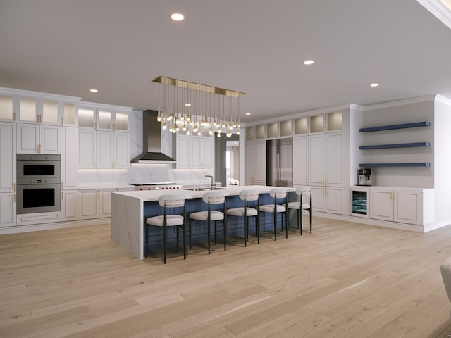 kitchen with hanging light fixtures, wall chimney range hood, stainless steel appliances, a spacious island, and crown molding