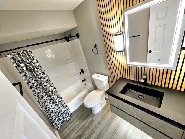 full bathroom featuring hardwood / wood-style flooring, lofted ceiling, shower / tub combo, vanity, and toilet