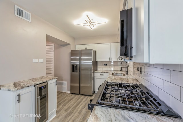 kitchen with white cabinetry, sink, stainless steel fridge with ice dispenser, and wine cooler