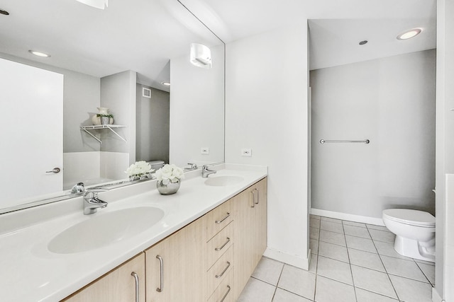 bathroom with tile patterned flooring, vanity, and toilet